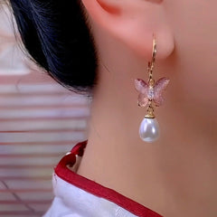 Model showcasing the dangle and style of the 14K Gold-Plated Luxury Butterfly Pearl Tassel Earrings
