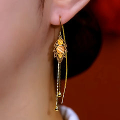 Model showcasing the dangle and style of the 14K Gold-Plated Luxury Cat's Eye Leaf Threader Tassel Earrings