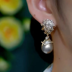Model showcasing the dangle and style of the 14K Gold-Plated Luxury Champagne Pearl Zircon Earrings