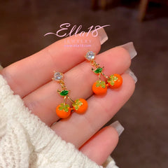 Model showcasing the dangle and style of the 14K Gold-Plated Luxury Design Zircon Diamond Persimmon Earrings