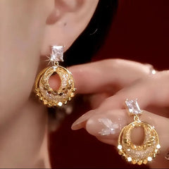 Model showcasing the dangle and style of the 14K Gold-Plated Luxury Diamond Hoop Earrings