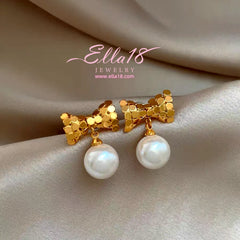 Model showcasing the dangle and style of the 14K Gold-Plated Luxury Geometric Bow Pearl Earrings