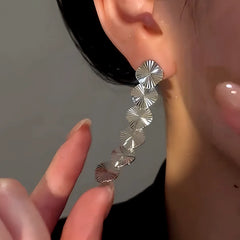 Model showcasing the dangle and style of the 14K Gold-Plated Luxury Glossy Feather Fan Tassel Earrings