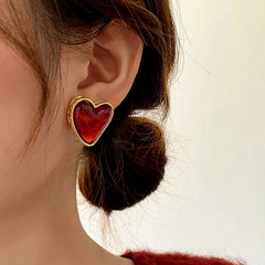 Model showcasing the dangle and style of the 14K Gold-Plated Luxury Red Heart Stud Earrings