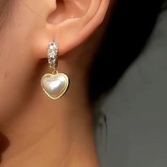 Model showcasing the dangle and style of the 14K Gold-Plated Luxury Rhinestone Heart Earrings