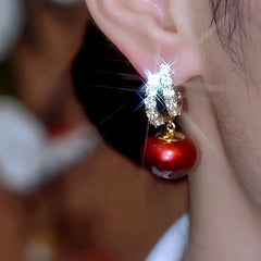 Model showcasing the dangle and style of the 14K Gold-Plated Luxury Sparkling Red Pearl Earrings