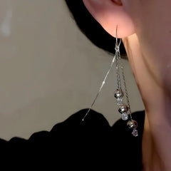 Model showcasing the dangle and style of the 14K Gold-Plated Luxury Zircon Bead Tassel Threader Earrings