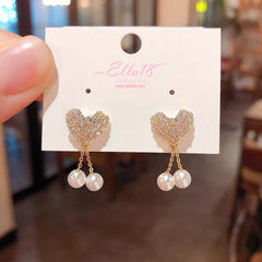 Model showcasing the dangle and style of the 14K Gold-Plated Luxury Zircon Diamond Heart Pearl Tassel Earrings