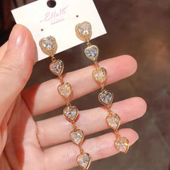 Model showcasing the dangle and style of the 14K Gold-Plated Luxury Zircon Diamond Heart Tassel Earrings