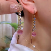 Rose gold pink bead crystal bow long dangle earrings pair shown on ear