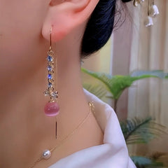 Rose gold pink bead crystal bow long dangle earring side view on ear