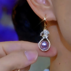 Model showcasing the dangle and style of the 14K Gold-Plated Luxury Zircon Purple Pearl Earrings
