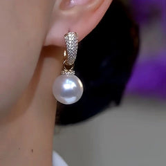 Model showcasing the dangle and style of the 14K Gold-Plated Luxury Zircon White Pearl Earrings