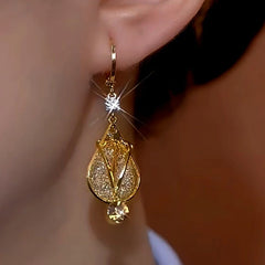 Front closeup of gold teardrop crystal drop earring on ear