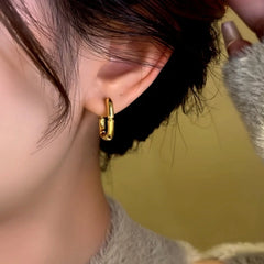 Side view of gold square bamboo hoop earring worn on woman's ear