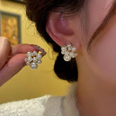 Elegant pearl cluster crystal stud earrings, hand holding matching pair beside worn ear