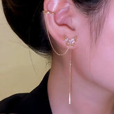 Gold butterfly ear cuff with long dangle chain worn on woman's ear
