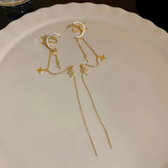 Gold celestial moon star tassel ear cuff pair, flat lay on white plate