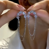 Pair of Women's Silver CZ U-Shaped Double Chain Drop Earrings Held in Hands
