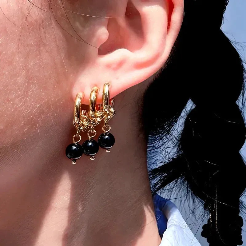 Model showcasing the dangle and style of the 14K Gold-Plated Multi-Layer Black Bead Tassel Earrings