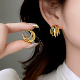 Gold multi-layer hoop earrings: one worn on ear, one held in hand