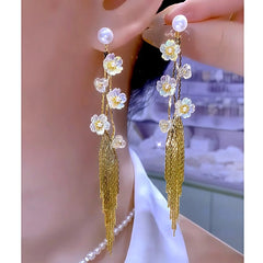 Long iridescent white flower gold tassel pearl drop earrings, one worn one held