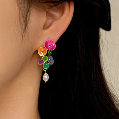 Side view of multicolor enamel flower cluster pearl drop earring on woman's ear