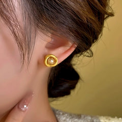 Model showcasing the dangle and style of the 14K Gold-Plated Pearl Frosted Swirl Bead Stud Earrings