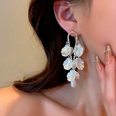 Model showcasing the dangle and style of the 14K Gold-Plated Pearl Petal Tassel Earrings