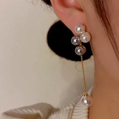 Model showcasing the dangle and style of the 14K Gold-Plated Pearl Tassel Earrings