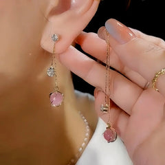 Angled view of the 14K Gold-Plated Pink Cat's Eye Ball Tassel Earrings