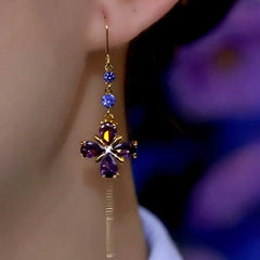 Purple crystal flower gold drop earring worn on ear, front angle