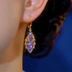 Side view of purple crystal gold leaf dangle earring on ear