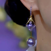 Gold tone purple rhinestone rhombus pearl drop earring worn on ear