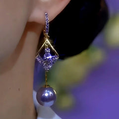 Side view of gold tone purple crystal pearl dangle earring on ear