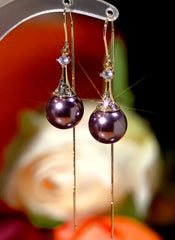 Pair of women's purple pearl long tassel drop earrings on display stand