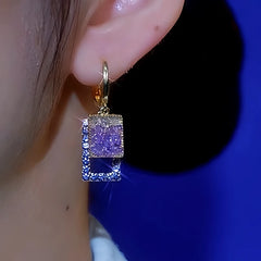 Women's gold purple and blue square crystal drop earring worn on right ear