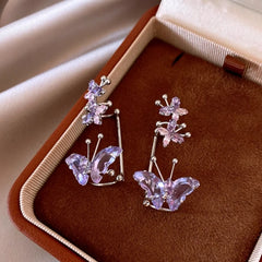 Pair of dainty purple crystal butterfly earrings displayed in velvet jewelry box