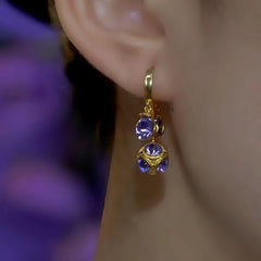 Front view gold purple crystal dangle earring worn on ear