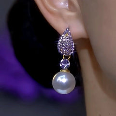 Sparkling purple teardrop rhinestone pearl dangle earring on ear