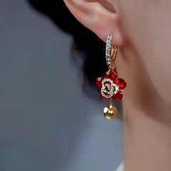Side view of red flower rhinestone gold ball drop hoop earring on ear