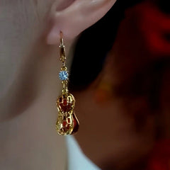 Model showcasing the dangle and style of the 14K Gold-Plated Red Pearl Peanut Earrings