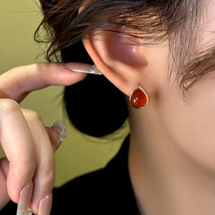 Model showcasing the dangle and style of the 14K Gold-Plated Red Water Drop Earrings