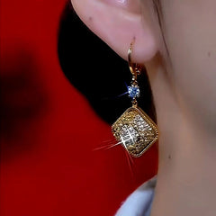 Model showcasing the dangle and style of the 14K Gold-Plated Retro Geometric Diamond Earrings