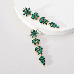 Angled view of the 14K Gold-Plated Rhinestone Flower Leaf Tassel Earrings