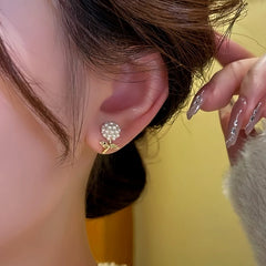 Model showcasing the dangle and style of the 14K Gold-Plated Rice Bead Flower Earrings