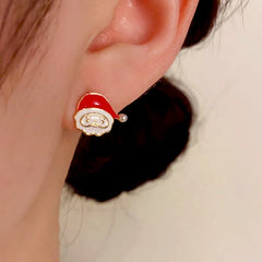 Model showcasing the dangle and style of the 14K Gold-Plated Santa Claus Stud Earrings