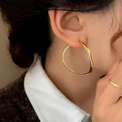 Model showcasing the dangle and style of the 14K Gold-Plated Simple Curvy Hoop Earrings