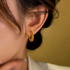 Model showcasing the dangle and style of the 14K Gold-Plated Smooth Flat Hoop Earrings