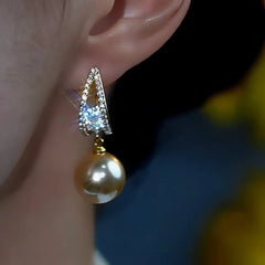 Model showcasing the dangle and style of the 14K Gold-Plated Sparkling Daimond Champagne Pearl Earrings